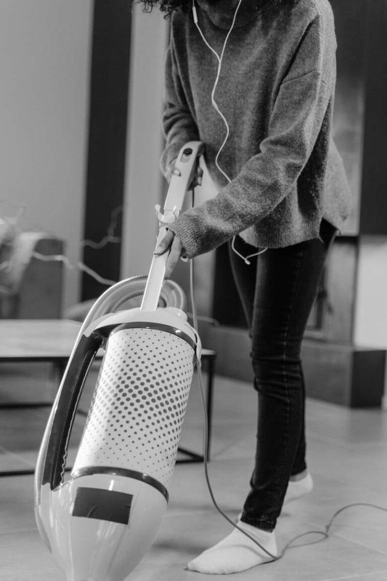 Grayscale Photo of a Person Cleaning using a Vacuum Cleaner