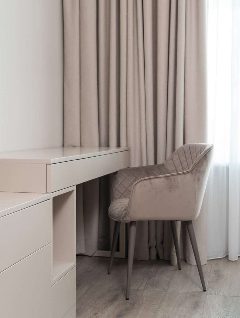 Interior of modern light room with table near chair and window with curtains