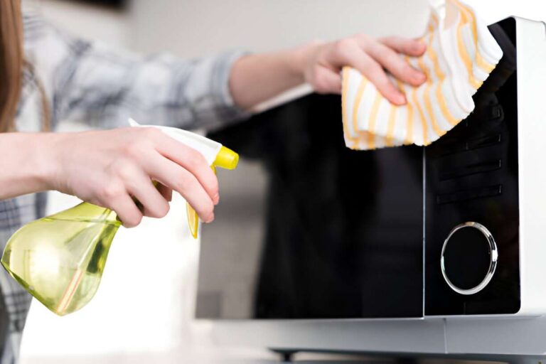 woman cleaning the microwave