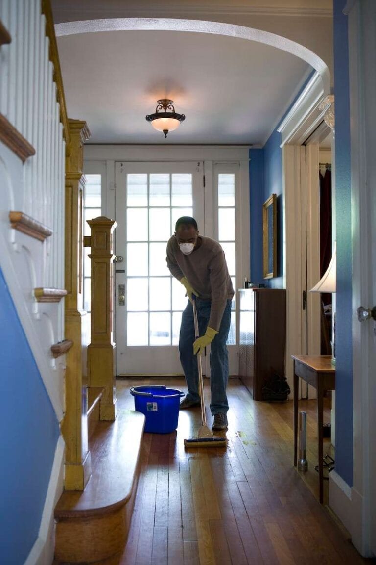 man cleaning the floor using mop